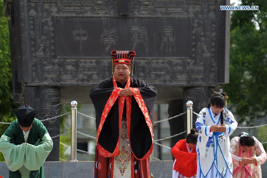 People in Han dresses attend a sacrificial ceremony for Qu Yuan, a patriotic poet who drowned himself before his state fell to the invasion of the enemy during the Warring States Period (475-221 BC), in Lanzhou, capital of northwest China's Gansu Province, June 9, 2016. 