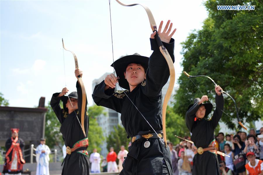 People in Han dresses perform arrow-shooting ritual during a sacrificial ceremony for Qu Yuan, a patriotic poet who drowned himself before his state fell to the invasion of the enemy during the Warring States Period (475-221 BC), in Lanzhou, capital of northwest China's Gansu Province, June 9, 2016.