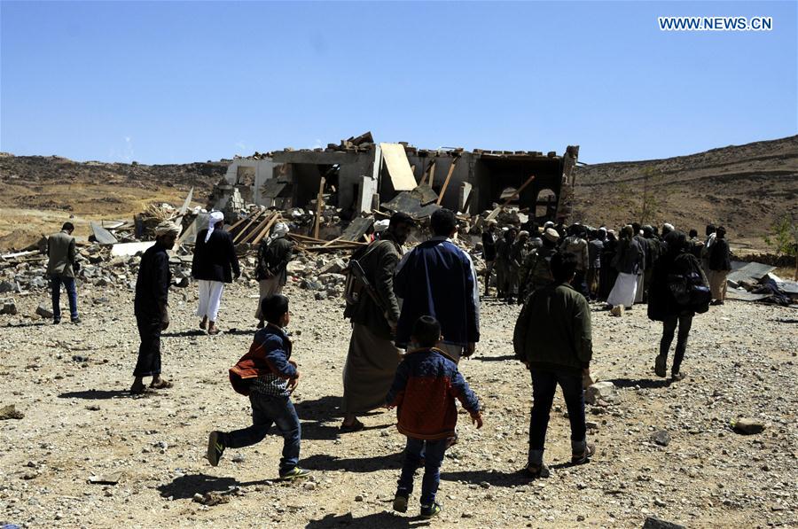 People walk toward a funeral house that was hit in airstrike in Arhab district, about 40 km north of Sanaa, capital of Yemen, on Feb. 16, 2017.