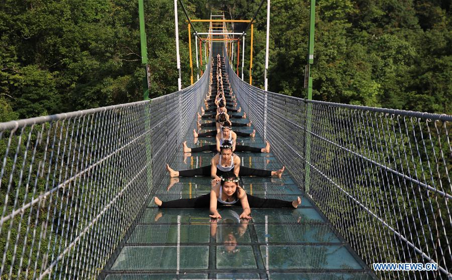 Yoga lovers practice yoga on glass bridge at S