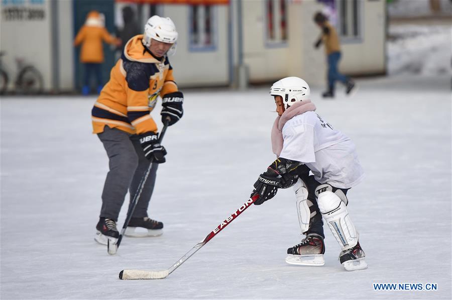 A child learns to play ice hockey at Nanhu park in Changchun, capital of northeast China's Jilin Province, Jan. 20, 2016. 