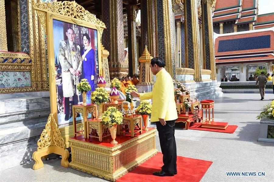 Thai Prime Minister Prayuth Chan-ocha (L, front) offers food to Buddhist monks outside the Grand Palace during the 70th anniversary celebrations of Thai King Bhumibol Adulyadej's accession to the throne in Bangkok, Thailand, June 9, 2016. 