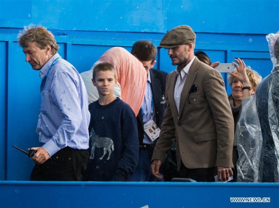 David Beckham (front R) walks off the court during a rain delay as he watches the men's singles first round match between Stan Wawrinka of Switzerland and Fernando Verdasco of Spain during day two of the ATP-500 Aegon Championships at the Queen's Club in London, Britain on June 14, 2016. 