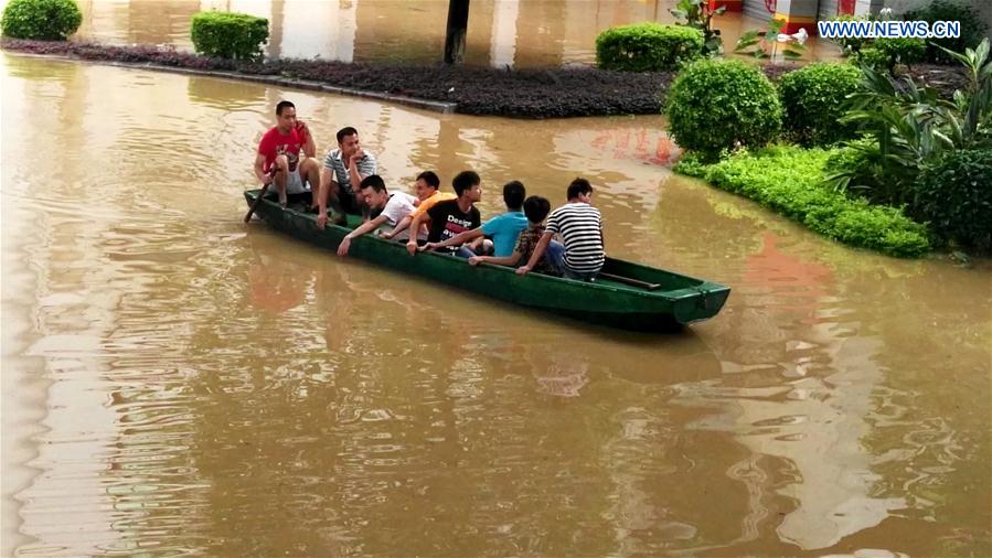 Residents sit on a boat on the flooded Bingjiang West Road in Liuzhou, south China's Guangxi Zhuang Autonomous Region, June 16, 2016.