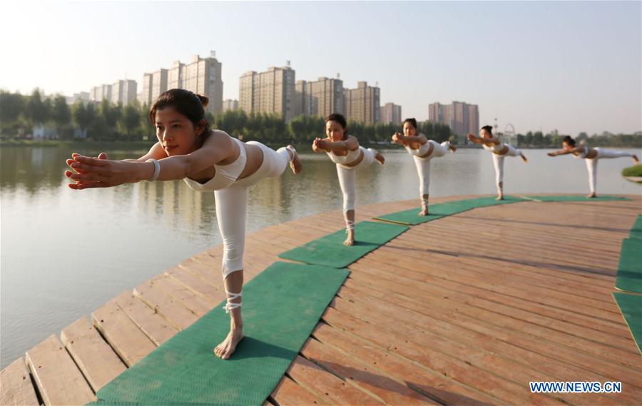 People practise yoga at the Longquan Lake Park in Wuzhi County of Jiaozuo, central China's Henan Province, June 18, 2016.