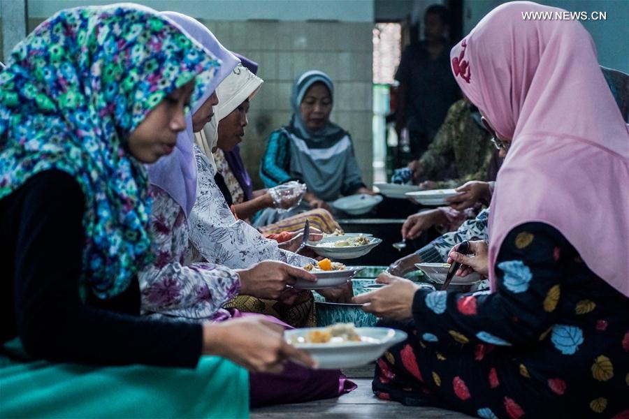 Indonesian Muslim women prepare porridge for Iftar, the evening meal during the Islamic month of Ramadan, at a mosque in Yogyakarta, Indonesia, June 17, 2016.