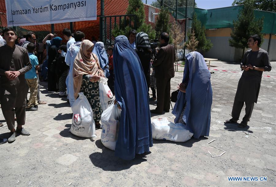 Afghan people prepare relief goods during the holy month of Ramadan in Kabul, capital of Afghanistan, June 20, 2016. 