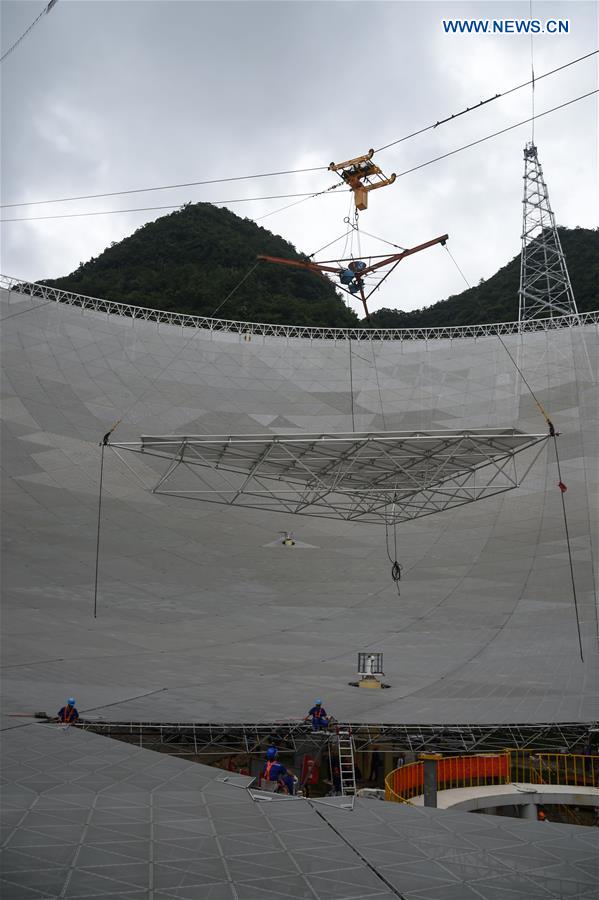 The last triangular panel to the reflector of the Five-hundred-meter Aperture Spherical Telescope (FAST) is being installed in Pingtang County, southwest China's Guizhou Province, July 3, 2016.