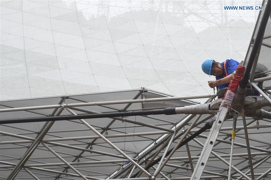 A worker installs the last triangular panel to the reflector of the Five-hundred-meter Aperture Spherical Telescope (FAST) in Pingtang County, southwest China's Guizhou Province, July 3, 2016.