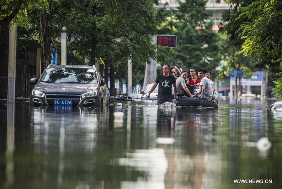 Rescuers push a car out of a flooded street in waterlogged Nanhu Lake area in Wuhan, capital of central China's Hubei Province, July 7, 2016.