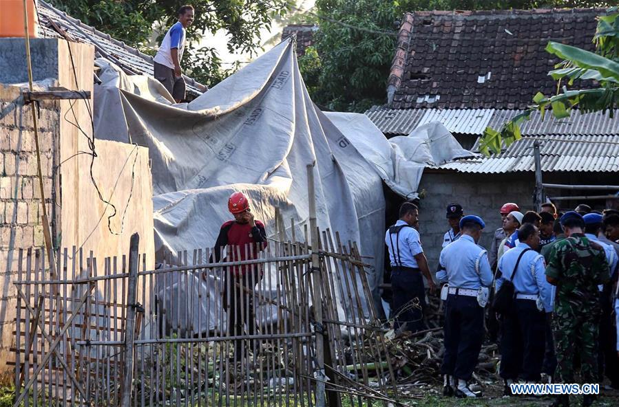 Indonesian military officers cover the site of a helicopter crash with tarpaulin at Sleman in Yogyakarta, Indonesia July 8, 2016. 