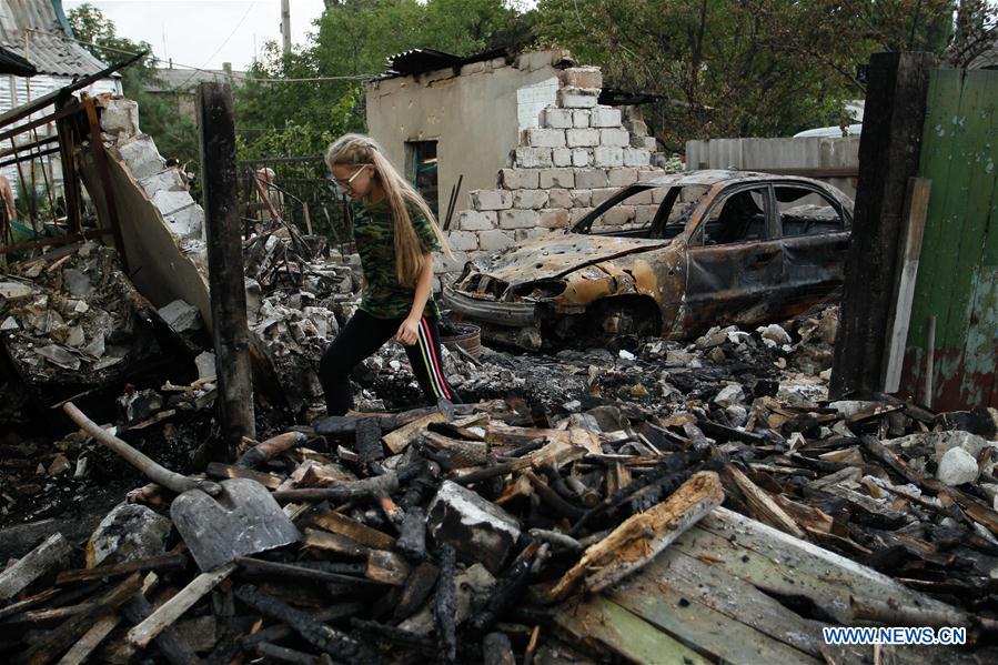 A girl is pictured in front of a damaged building in Gorlovka, eastern Ukraine, on July 10, 2016.