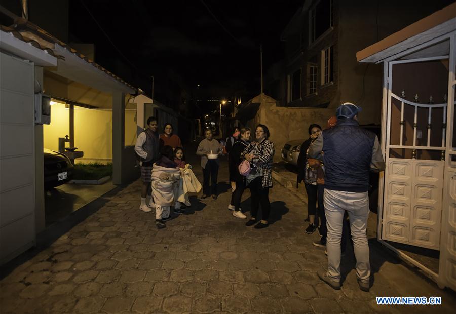 People stay on a street after earthquakes in Quito, Ecuador, on July 10, 2016. 