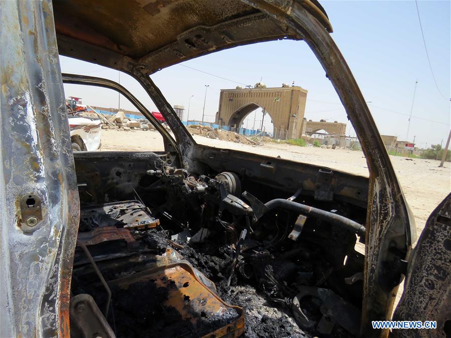 A man inspects a car damaged in an explosion at a crowded checkpoint in Husseiniyah neighborhood in Baghdad, capital of Iraq, on July 13, 2016.