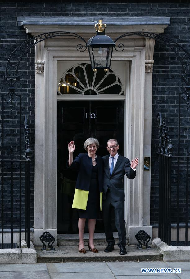 Britain's new Prime Minister Theresa May(L) and her husband pose for photos in front of 10 Downing Street in London, Britain on July 13, 2016.