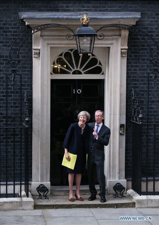Britain's new Prime Minister Theresa May(L) and her husband pose for photos in front of 10 Downing Street in London, Britain on July 13, 2016.