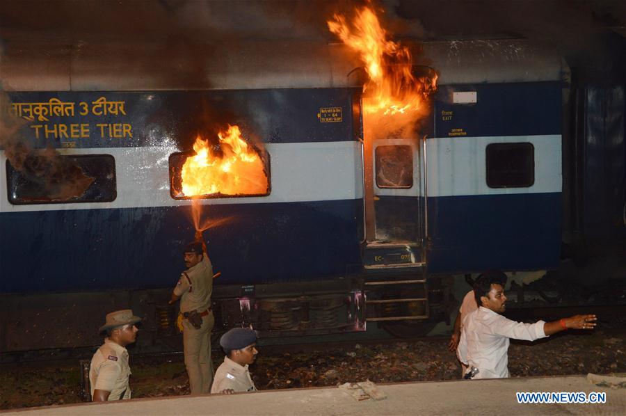 Police try to put out the fire on a train coach at Rajendra Nagar Terminal in Patna, India, on July 22, 2016. 