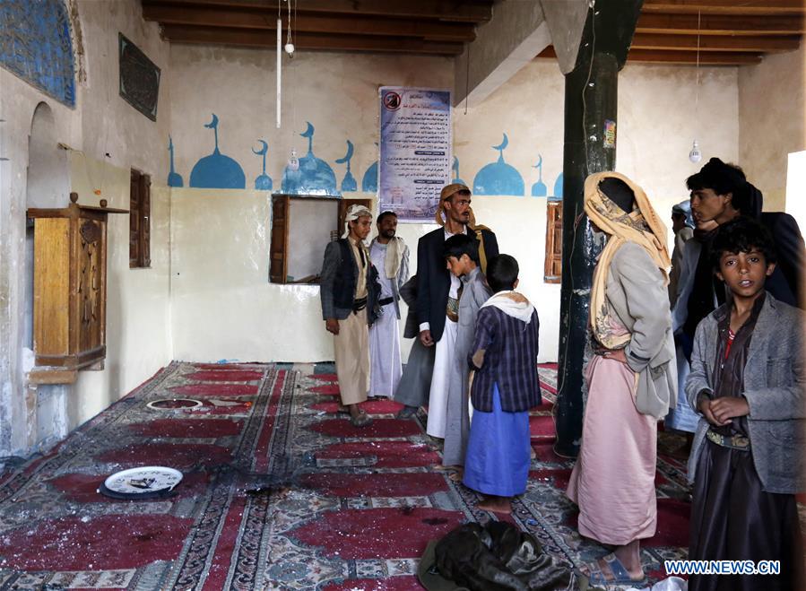 People inspect the mosque attacked by a gunman in Yemen's capital of Sanaa on July 27, 2016.