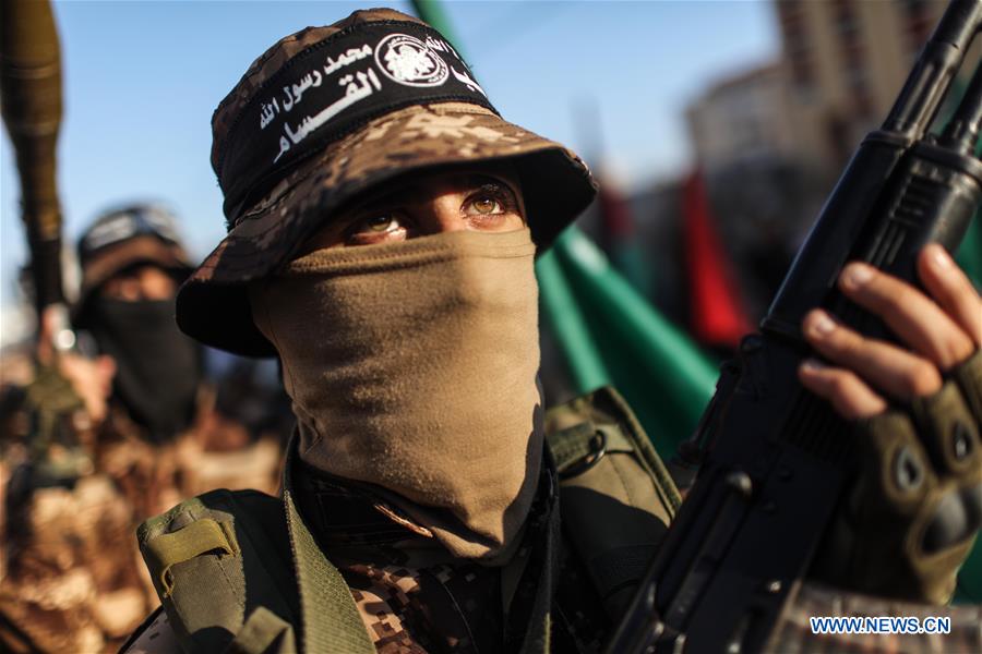 Palestinian members of the al-Qassam Brigades, the armed wing of the Hamas movement, hold their weapons during a military parade in Gaza City, on July 28, 2016