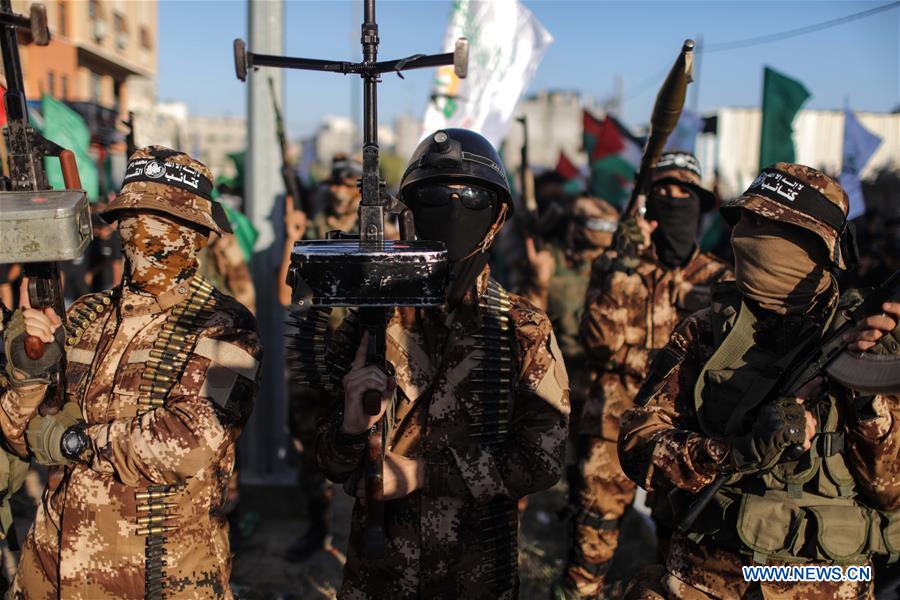 Palestinian members of the al-Qassam Brigades, the armed wing of the Hamas movement, hold their weapons during a military parade in Gaza City, on July 28, 2016