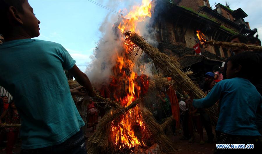 Locals cheer after setting fire on the dummy of demon Ghantakarna during the Ghantakarna Festival in Bhaktapur, Nepal, Aug. 1, 2016. 