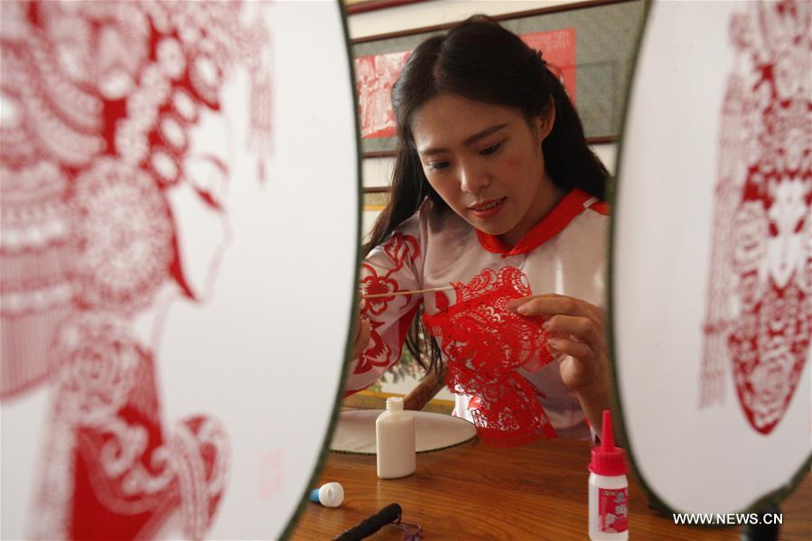 Liang has made over 40 kinds of handiworks of paper cutting as she combined the cutting with porcelain, statue, cloth and etc.