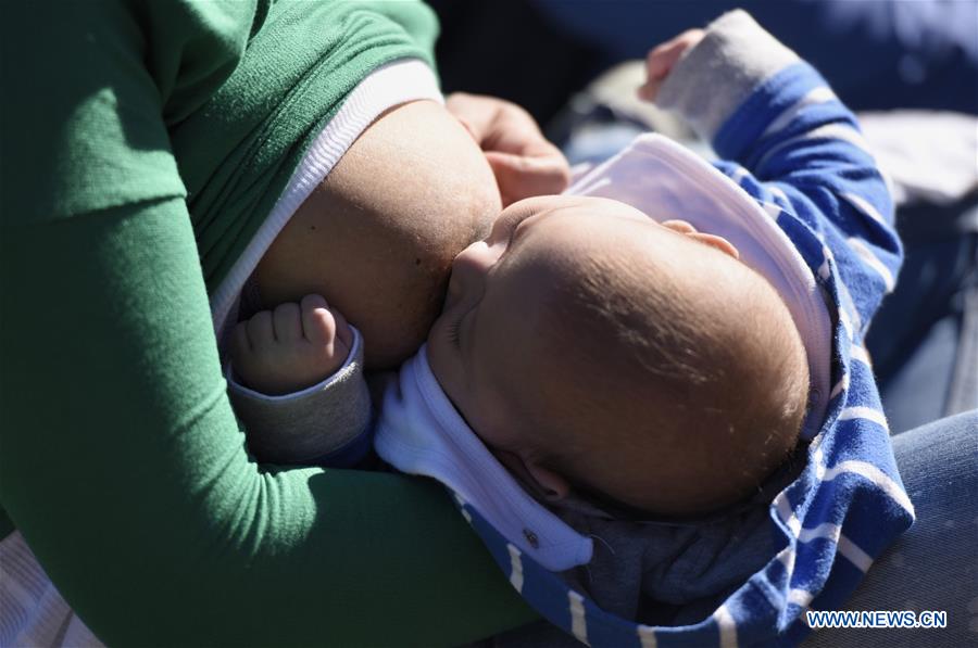 A woman feeds her child on the promotion day of breastfeeding called 'Tetada Masiva' in the Rodo Park in Montevideo, capital of Uruguay, on Aug. 7, 2016. 