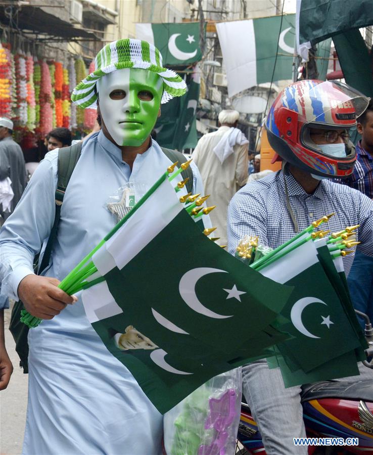 A Pakistani vendor (L) sells flags on a street ahead of the country's Independence Day in eastern Pakistan's Lahore, Aug. 11, 2016. 