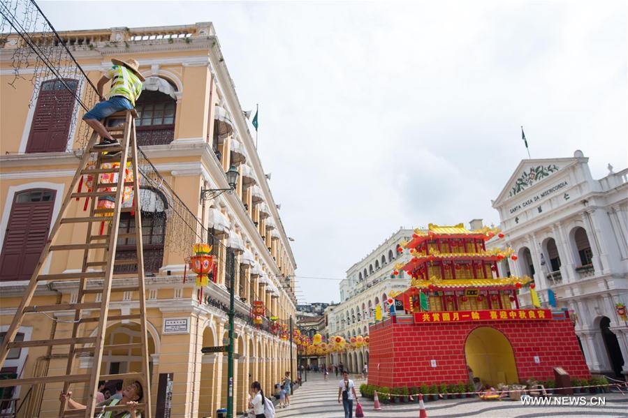 Workers arrange light decorations ahead of the Mid-Autumn Festival at the Largo Do Senado in Macao, south China, Sept. 6, 2016. 