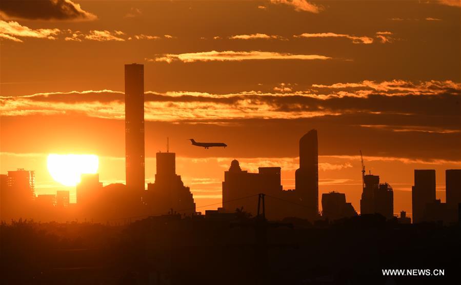 An airplane flies over Manhattan as the sun sets in New York, the United States, Sept. 7, 2016.