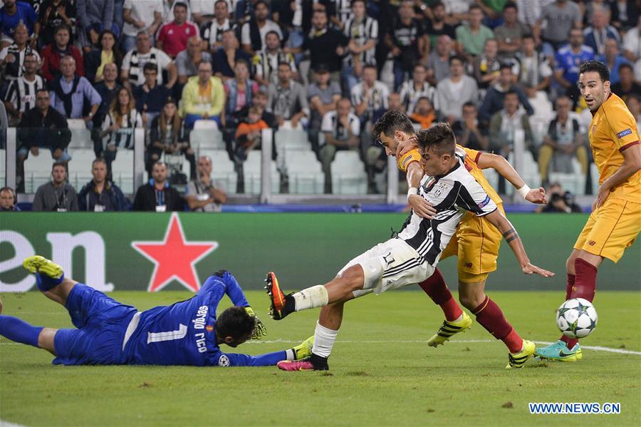 Paulo Dybala (R3) of Juventus vies with Sevilla's goalkeeper Sergio Rico (L) during the UEFA Champions League soccer match in Turin, Italy, Sept. 14, 2016. 