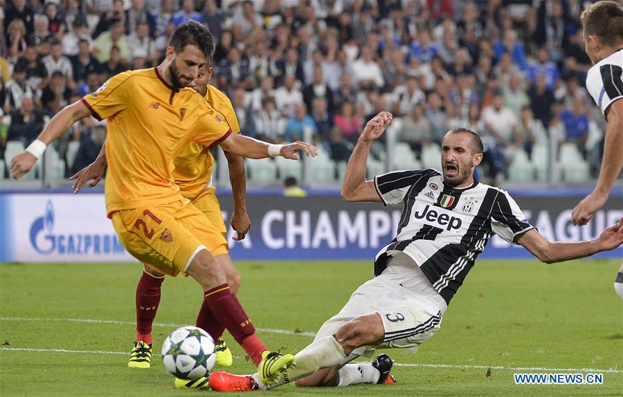 Giorgio Chiellini (R) of Juventus vies with Nicolas Pareja of Sevilla during the UEFA Champions League soccer match in Turin, Italy, Sept. 14, 2016. 