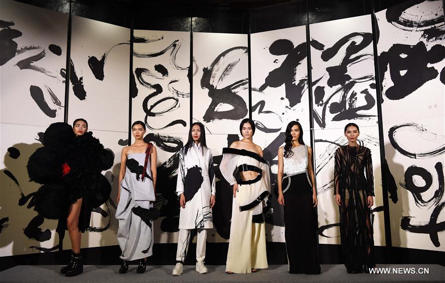 A model presents a creation with Chinese calligraphy elements during a fashion show in Taipei, southeast China's Taiwan, Oct. 12, 2016. 