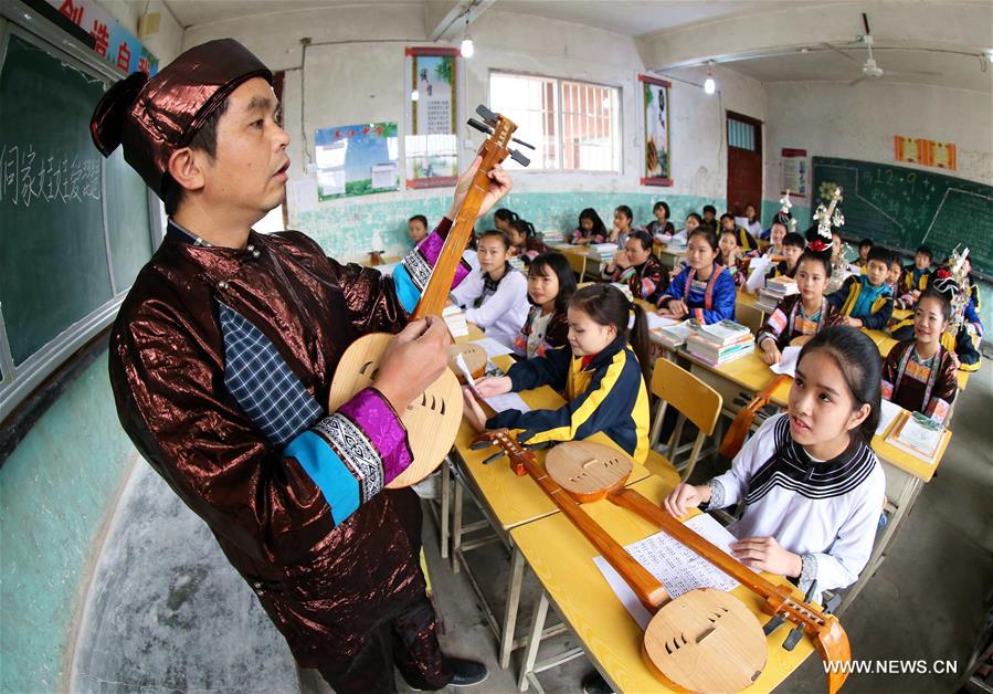 A teacher of Dong ethnic group teaches the skills of playing Pipa, a folk instrument, at Chejiang Minzu Middle School in Rongjiang County, southwest China's Guizhou Province, Dec. 8, 2016.(N)