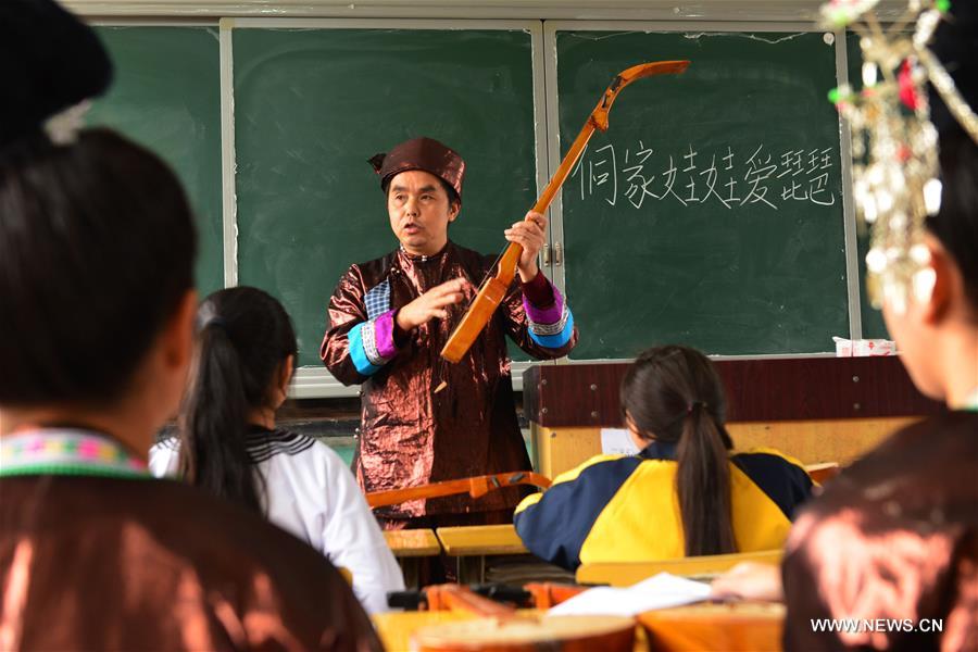 A teacher of Dong ethnic group teaches the skills of playing Pipa, a folk instrument, at Chejiang Minzu Middle School in Rongjiang County, southwest China's Guizhou Province, Dec. 8, 2016.(