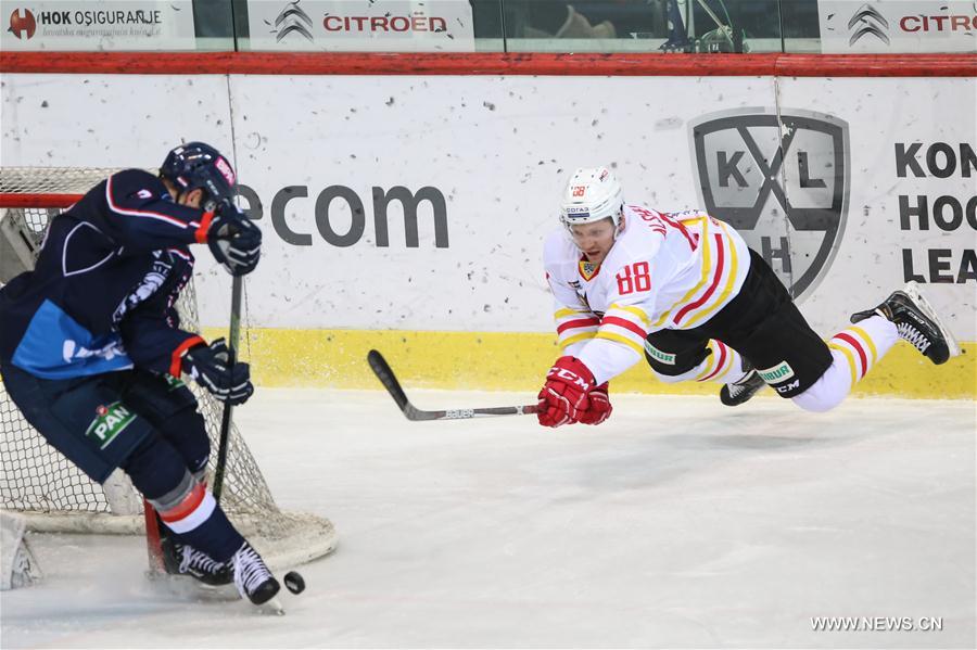 Yaroslav Alshevsky (R) of Beijing Kunlun Redstar hits the puck during the Kontinental Hockey League (KHL) match against Medvescak Zagreb in Zagreb, capital of Croatia, Jan. 3, 2017. Medvescak Zagreb won 1-0. (Xinhua/Igor Soban) 