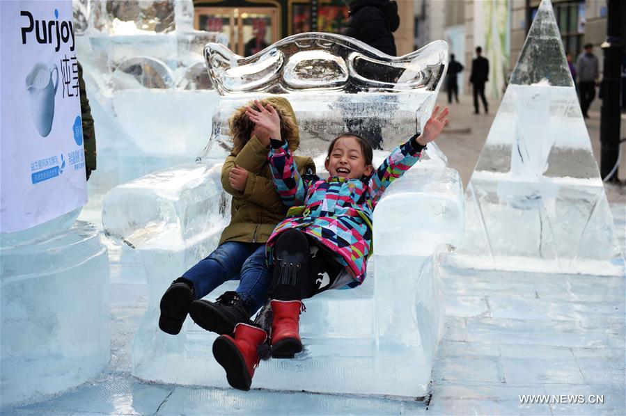 A tourist views ice sculptures on Harbin Central Avenue in Harbin, capital of northeast China's Heilongjiang Province, Jan. 6, 2017.
