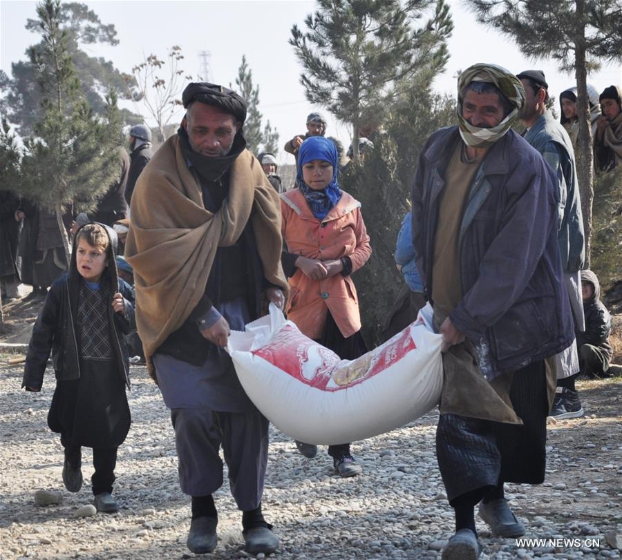Afghan people carry winter relief assistance donated by Afghan government in Jawzjan province, Afghanistan, Jan. 18, 2017. (Xinhua/Mohammad Jan Aria)