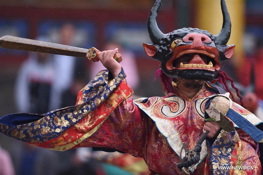 A monk performs 'Tiaoqian', a masked religious dance with a history of nearly 300 years, at the Kumbum Monastery in Huangzhong County, northwest China's Qinghai Province, Feb. 10, 2017. 