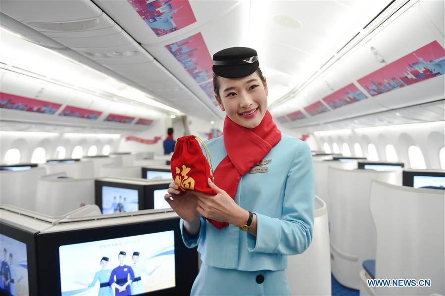 A stewardess shows a gift prepared for passengers on the flight MF849 at the Fuzhou International Airport in Fuzhou, capital of southeast China's Fujian Province, Feb. 15, 2017. MF849, the first direct flight of Xiamen Airlines from Fuzhou to New York, took off here on Wednesday. 