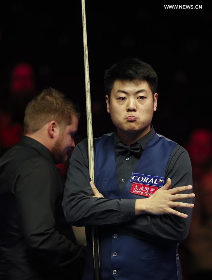 Liang Wenbo (R) of China reacts during the second round match against Michael White of Wales at Welsh Open 2017 in Cardiff, Wales, Britain on Feb. 15, 2017. 