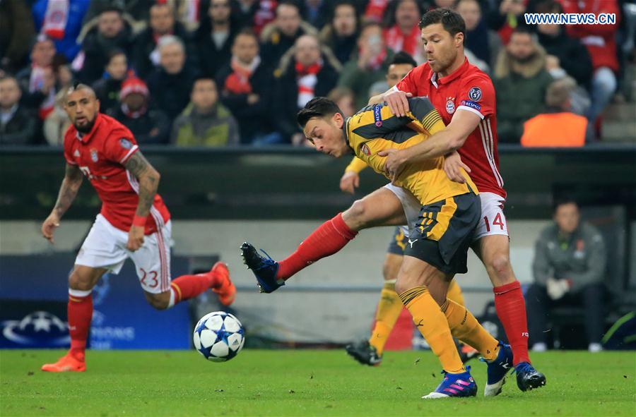 Arsenal's Mesut Oezil (L, Front) vies with Bayern Munich's Xabi Alonso (R, Front) during the first leg match of Round of 16 of European Champions League between Bayern Munich and Arsenal in Munich, Germany, on Feb. 15, 2017. 