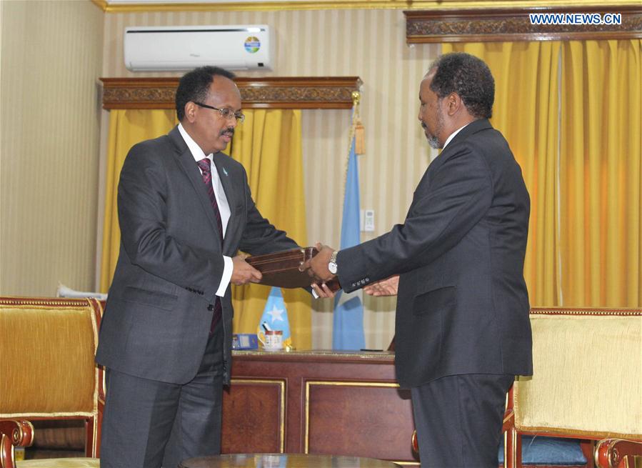 The outgoing President Hassan Sheikh Mohamud (R) hands over documents to the incoming President Mohamed Abdullahi Farmajo (L) during the handover ceremony at the presidential palace Villa Somalia in Mogadishu, capital of Somalia, Feb. 16, 2017. 