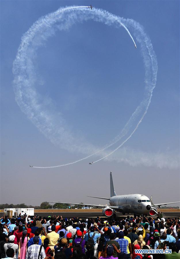 Spectators watch performance of helicopters during the Aero India 2017 at the Indian Air Force base of Yelahanka in Bangalore, India, Feb. 17, 2017.