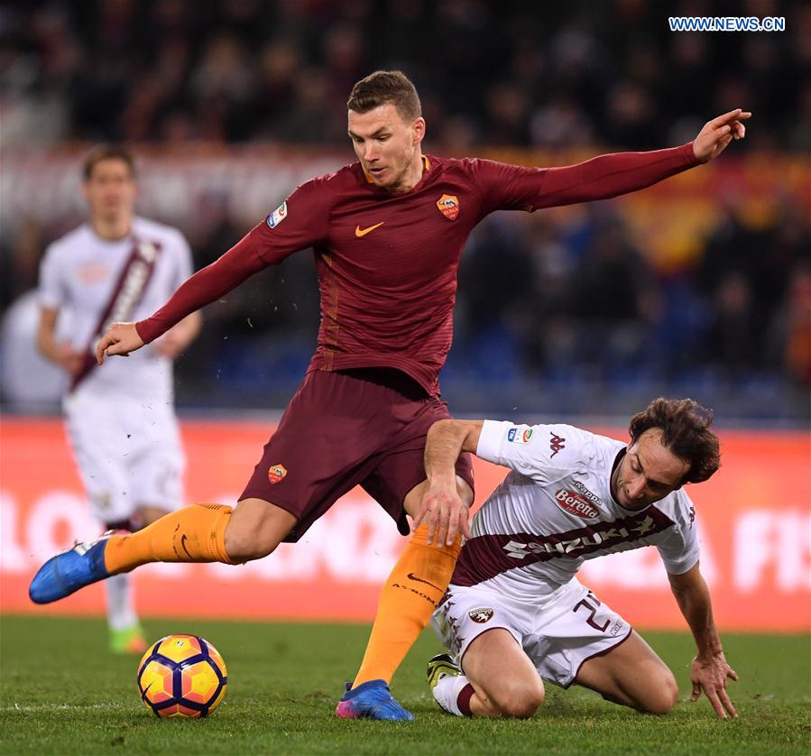 Roma's Edin Dzeko (L) competes with Torino's Emiliano Morett during their Serie A soccer match in Rome, Italy, Feb. 19, 2017.
