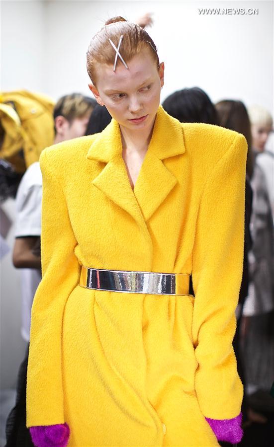 A model has her clothes changed backstage before ANNAKIKI show during Milan Fashion Week Fall-Winter 2017-18 in Milan, Italy on Feb. 22, 2017.