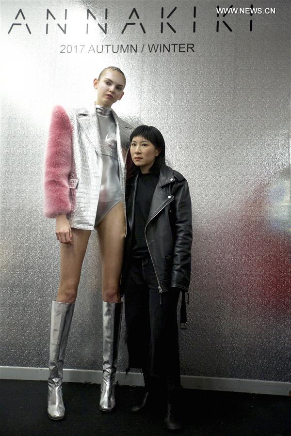Chinese designer Yangzi (R) poses for a photo with her model backstage before ANNAKIKI show during Milan Fashion Week Fall-Winter 2017-18 in Milan, Italy on Feb. 22, 2017.