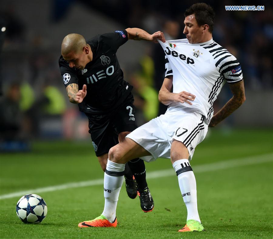 Porto's Maxi Pereira (L) vies with Juventus' Mario Mandzukic during the first leg match Round of 16 of the UEFA Champions League between FC Porto and Juventus FC at Dragon stadium in Porto, Portugal, Feb. 22, 2017. 