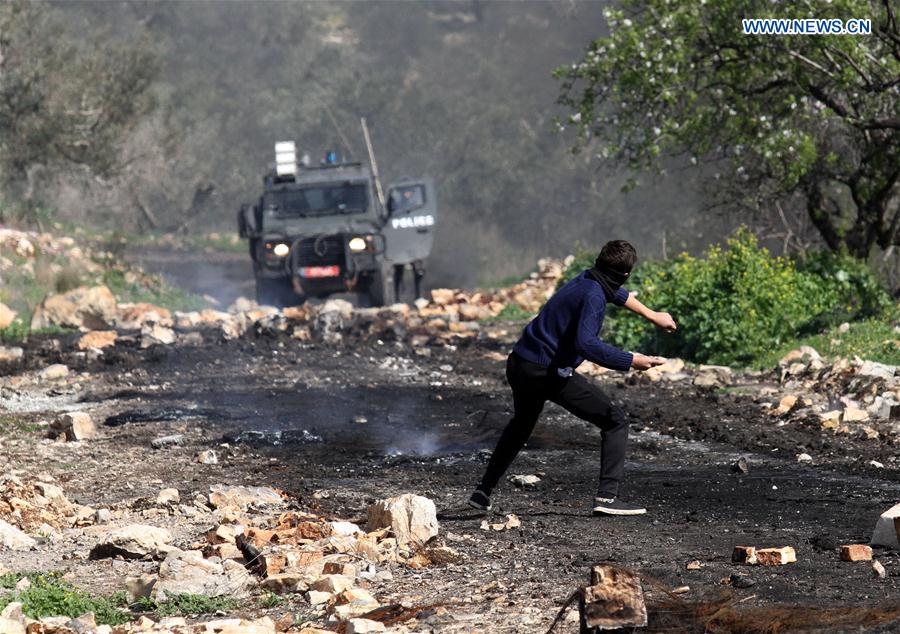 A Palestinian protester hurls a stone at Israeli soldiers during clashes after a protest against the expanding of Jewish settlements in Kufr Qadoom village near the West Bank city of Nablus, on Feb. 24, 2017. 
