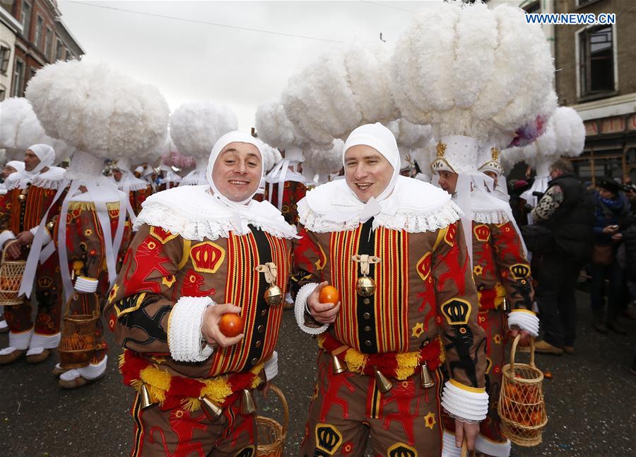 'Gilles' wearing hats adorned with huge white ostrich feather plumes march and hold oranges symbolizing the coming Spring, in Binche, Belgium, on Feb. 28, 2017. 